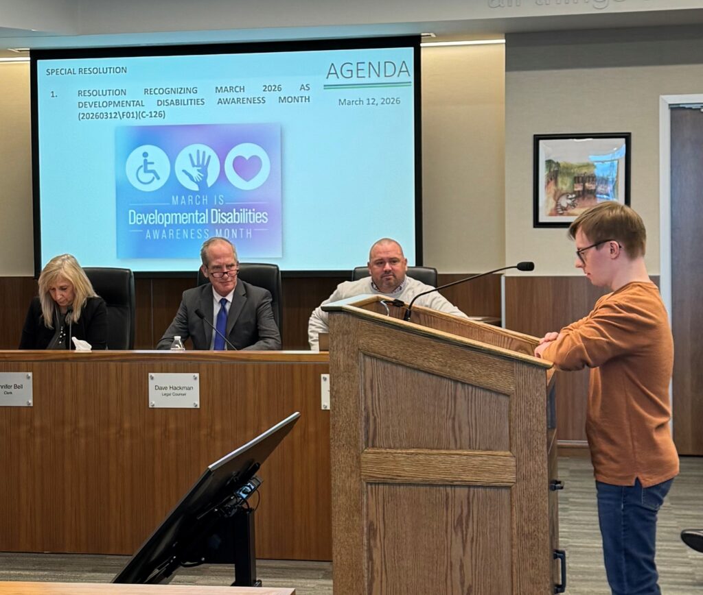 Sam Majoros presenting at the podium during the Lake County Commissioners Meeting 3-12-2026 to the local public officials for Developmental Disabilities Awareness Month.